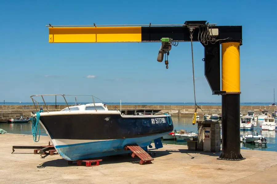 A crane lifting a boat in a boatyard