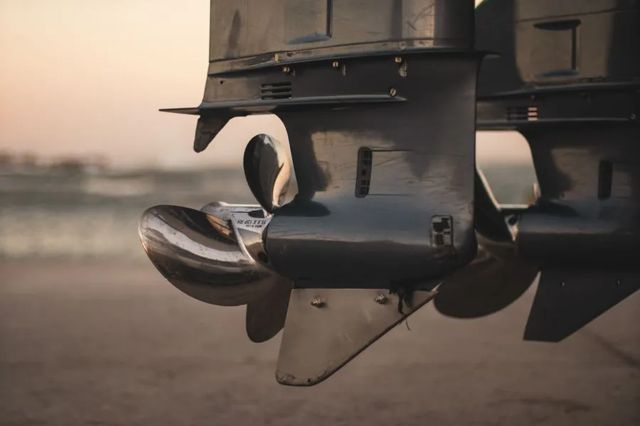 Close-up of an outboard lower unit and propeller at sunset